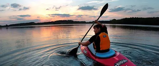 A kayaker on the water at sunrise.